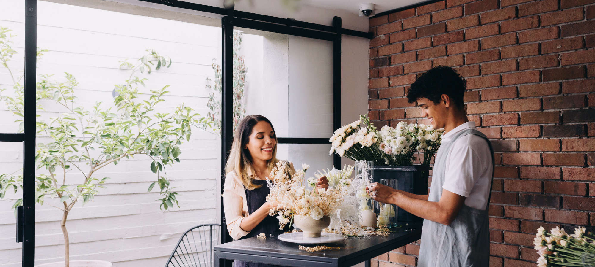 team of florists arranging modern white bouquet
